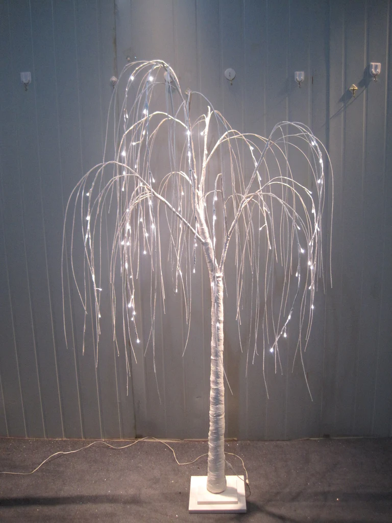 A stunning white weeping willow tree adorned with shimmering white lights.